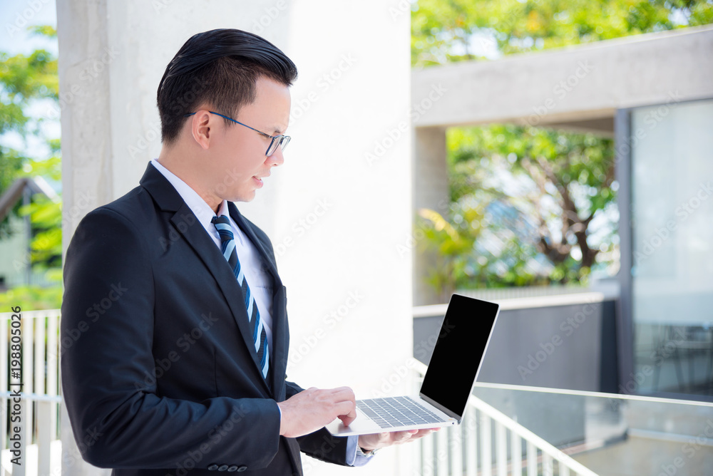 Young asian businessman wearing suit using laptop computer outdoor Young asian businessman wearing suit using laptop computer outdoor
