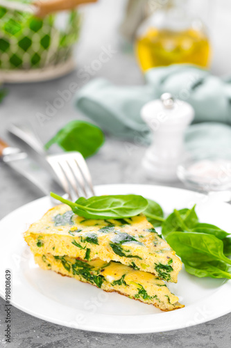 Omelet with spinach leaves. Omelette on plate, scrambled eggs