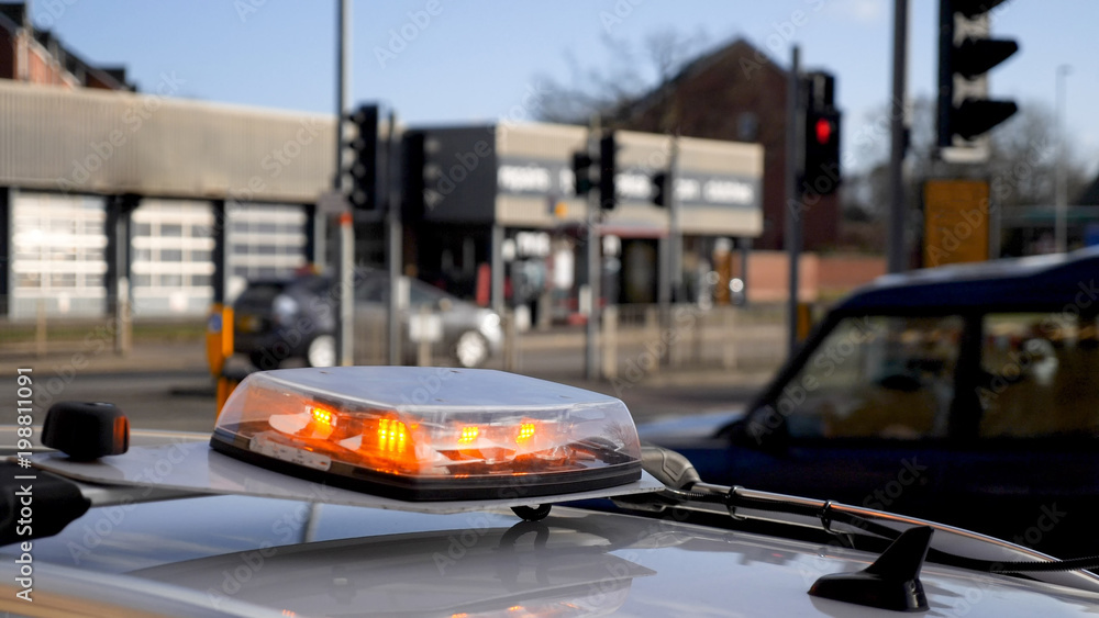 Day view medium shot of emergency light beacon flasher on roof of maintenance car on British road Day view medium shot of emergency light beacon flasher on roof of maintenance car on British road