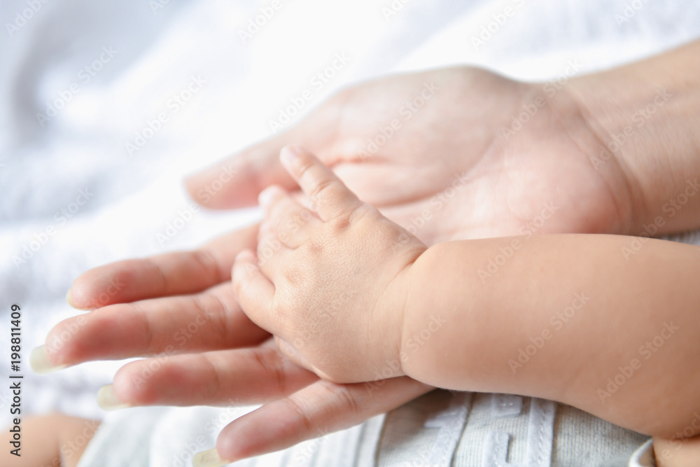 Newborn Concept. Mother and child on a white bed. Mom and baby boy playing in bedroom. Parent and little kid relaxing at home. Family having fun together. Newborn baby is fussing and crying. Newborn Concept. Mother and child on a white bed. Mom and baby boy playing in bedroom. Parent and little kid relaxing at home. Family having fun together. Newborn baby is fussing and crying.