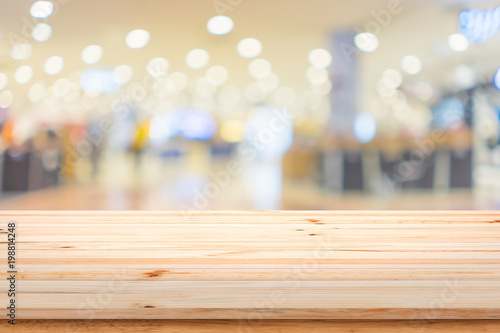 Empty top of wooden table with blur shopping mall background.
