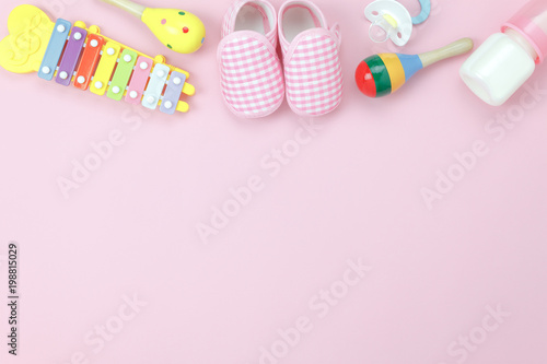 Table top view decoration kid toys for develop background concept.Flat lay baby shoes with items child on modern pink paper at office desk.Copy space for add text.Creative deign pastel tone wallpaper.