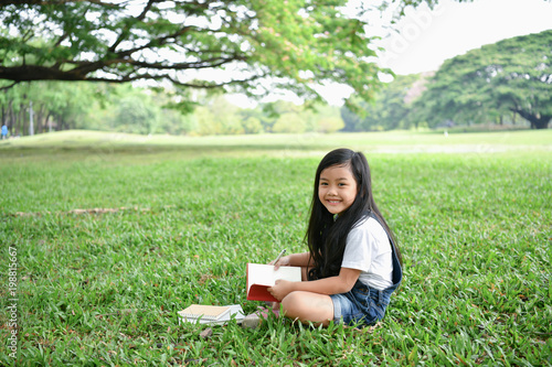 Education Concepts. The girl is reading a book in the garden. Beautiful girl is seriously studying. Beautiful girls are happy learning.