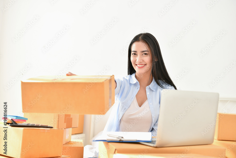 Sme business concept. Young people are packing their packages.Delivery business Small and Medium Enterprise (SMEs). Young woman is working in the house.Young Owner Start up for Business Online. Sme business concept. Young people are packing their packages.Delivery business Small and Medium Enterprise (SMEs). Young woman is working in the house.Young Owner Start up for Business Online.