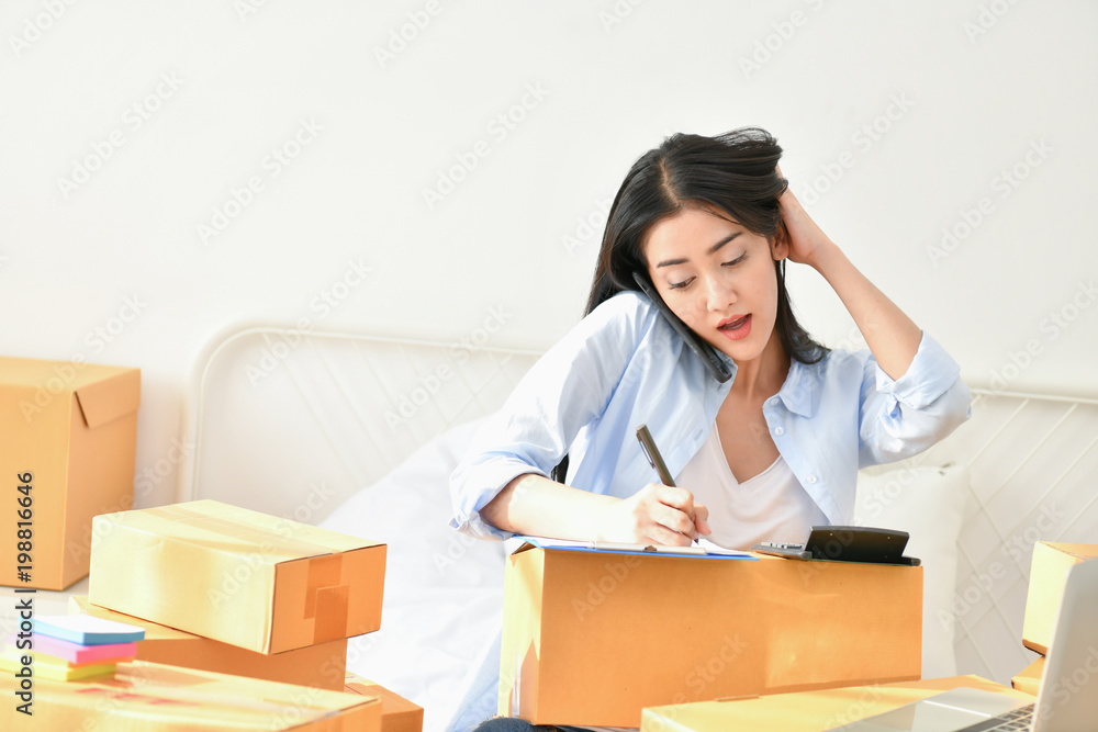 Sme business concept. Young people are packing their packages.Delivery business Small and Medium Enterprise (SMEs). Young woman is working in the house.Young Owner Start up for Business Online. Sme business concept. Young people are packing their packages.Delivery business Small and Medium Enterprise (SMEs). Young woman is working in the house.Young Owner Start up for Business Online.