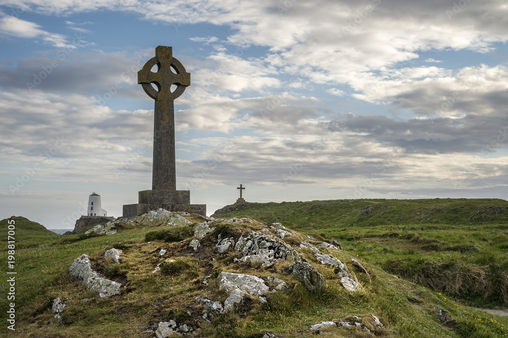 View of Celtic Cross on Angelsey with Twr Mawr Lighthouse in background landscape View of Celtic Cross on Angelsey with Twr Mawr Lighthouse in background landscape