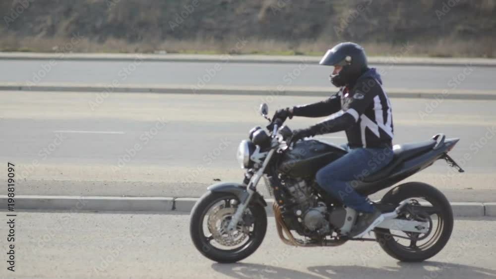 young attractive man motorcyclist with black helmet and sport motorcycle on street young attractive man motorcyclist with black helmet and sport motorcycle on street