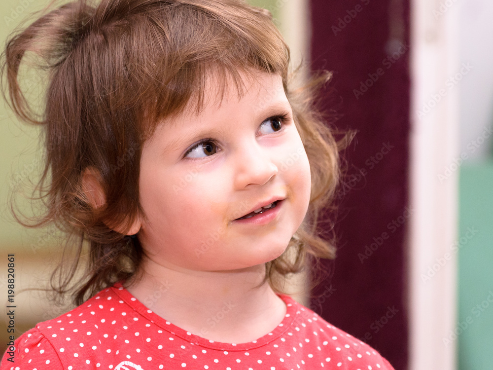 A small three-year-old European girl is smiling. Picture of the face, portrait. A small three-year-old European girl is smiling. Picture of the face, portrait.