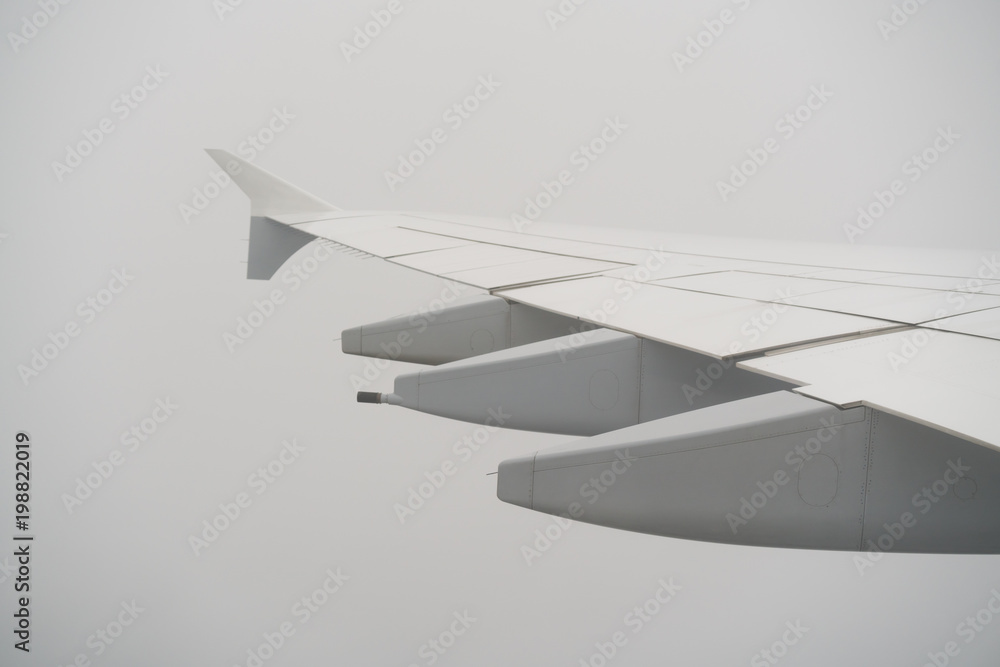 Naklejka premium airplane wing during flight in heavy clouds