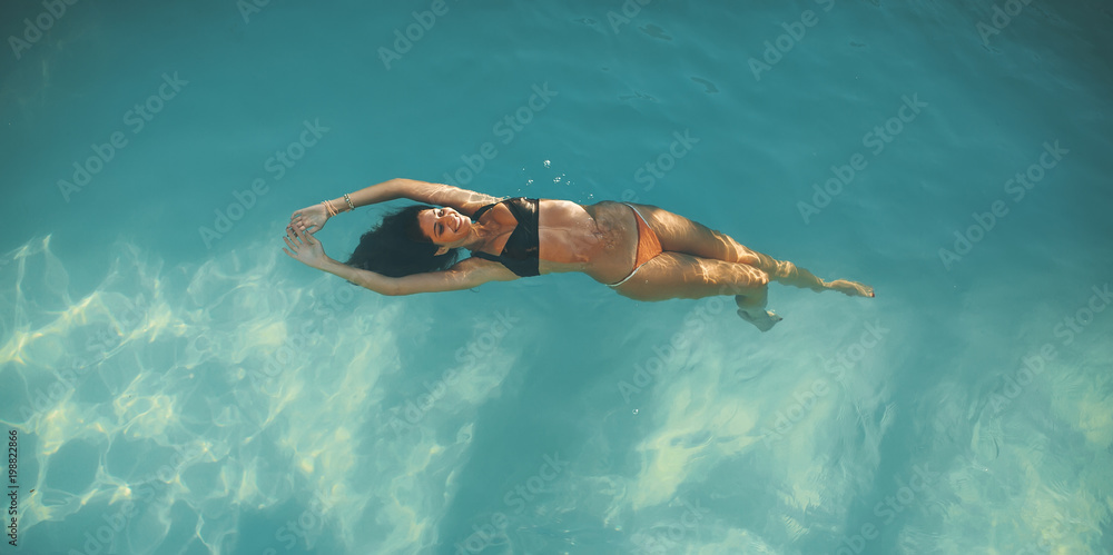 Young woman floating in the pool