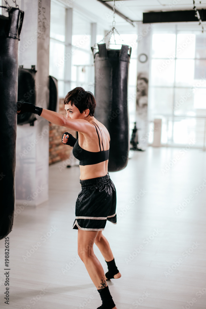vertical side view image of fit female participating in boxing sport event. get training.