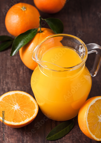 Glass jar of raw organic fresh orange juice on wood