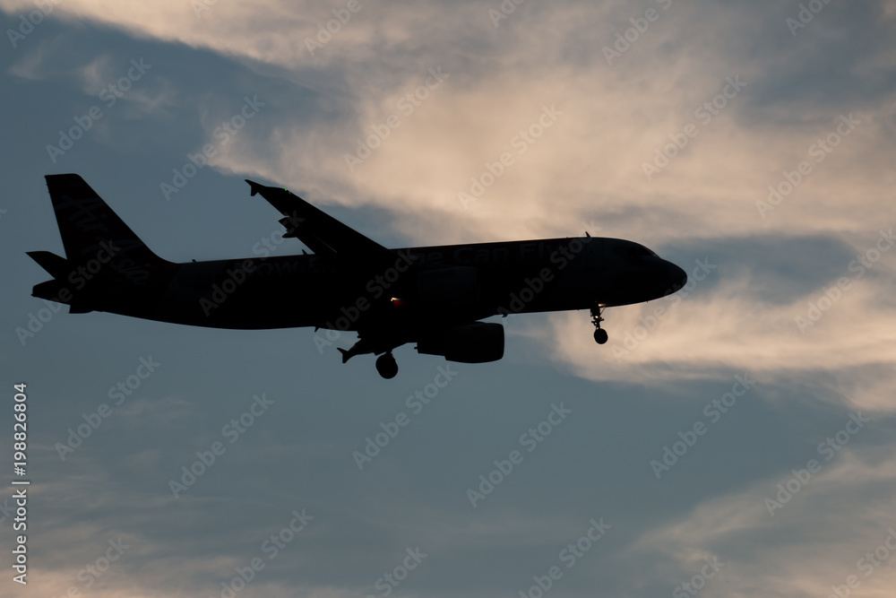 Silhouette passenger airplane flying away in to sky high altitude on sunset Silhouette passenger airplane flying away in to sky high altitude on sunset