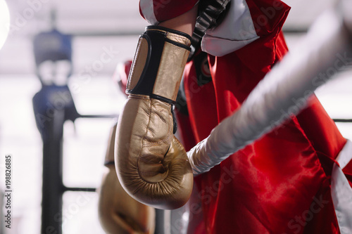 beaten boxer in yellow boxing gloves leaning on ropes. lost battle. without force. lost fight. defeat of an opponent photo