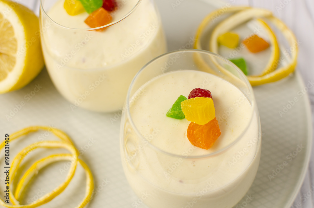 Sweet lemon mousse with candied fruits in glasses Sweet lemon mousse with candied fruits in glasses