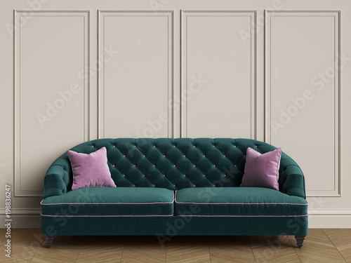 Tufted green sofa with pink pillows in classic interior with copy space