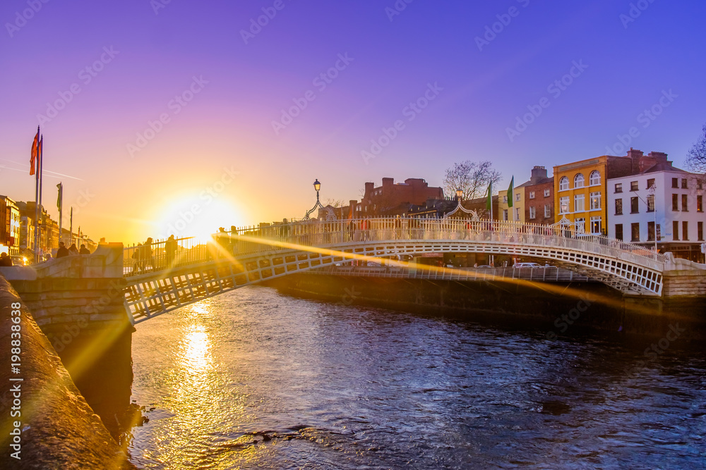 Obraz premium Most Ha'penny nad rzeką Liffey o zachodzie słońca, Dublin Irlandia, marzec 2018 r
