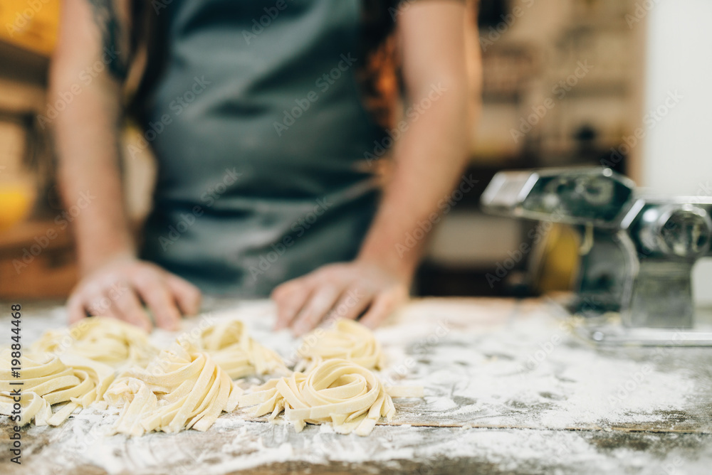 Chef against kitchen table with homemade pasta