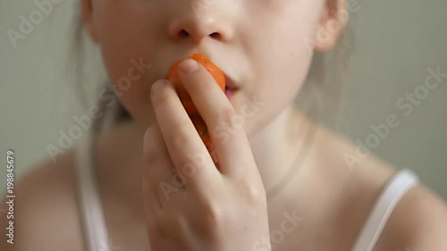 girl eating carrot close-up
