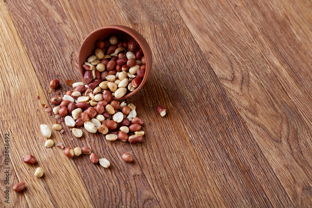 Two ceramic bowls with raw peanuts mix isolated over rustic wooden backround, top view, close-up. Two ceramic bowls with raw peanuts mix isolated over rustic wooden backround, top view, close-up.