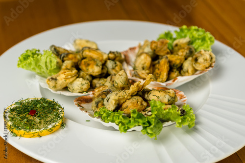 Seafood. fired Mussels appetizer with lemon served on Clam shells.Top view. Wooden background.