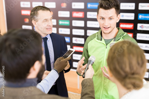 Foto Group of highly professional reporters standing at talented young athlete and in