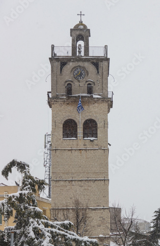 Kozani town, Greece. Snowy belfry of Saint Nikolaos orthodox church. Misty sky background. photo