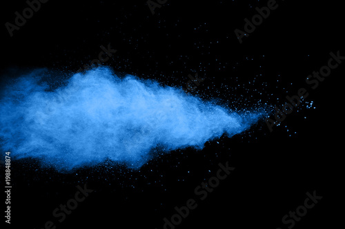 Abstract blue dust explosion on black background. Abstract blue powder splattered on dark background. Freeze motion of blue particles splashing. Painted Holi in festival festival.