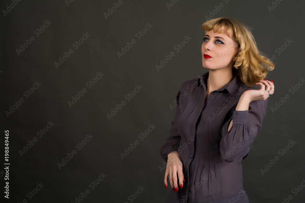 A woman with blond hair dressed in a gray shirt. Posing in the Studio on a gray background.
A woman with blond hair dressed in a gray shirt. Posing in the Studio on a gray background.
