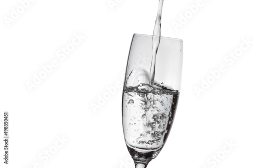 Pouring water into the glass isolated on white background.