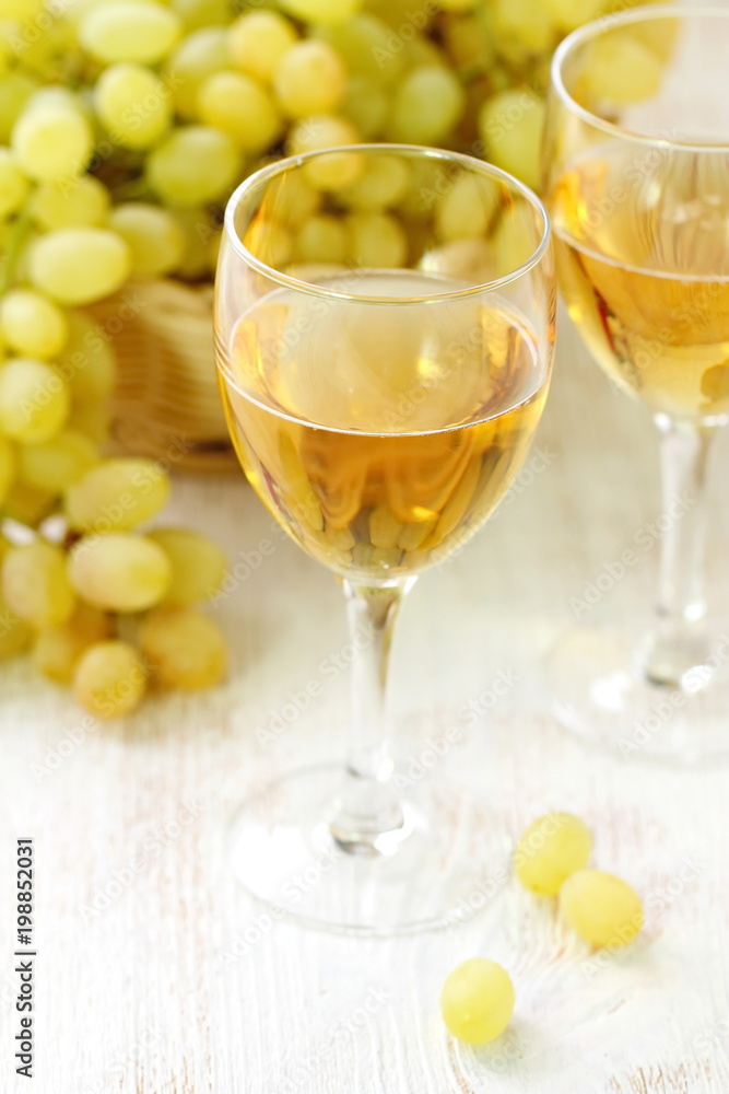 Glass of wine and grapes in the basket on a wooden table. Glass of wine and grapes in the basket on a wooden table.