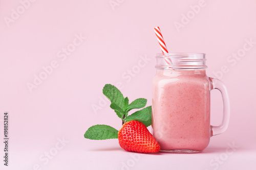 Fotografie, Obraz Strawberry smoothie or milkshake in mason jar decorated mint on pink table