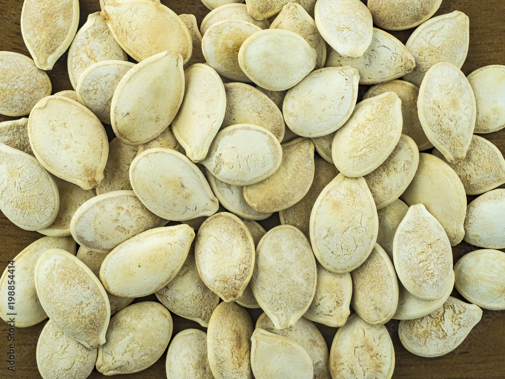 Pumpkin seeds roasted close-up on a wooden table. Pumpkin seeds roasted close-up on a wooden table.