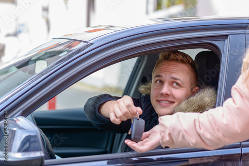 Quadro em tela Smiling young man in a car handing over his keys