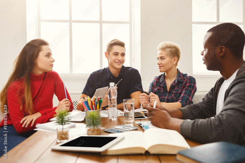Group of diverse students studying at wooden table Group of diverse students studying at wooden table