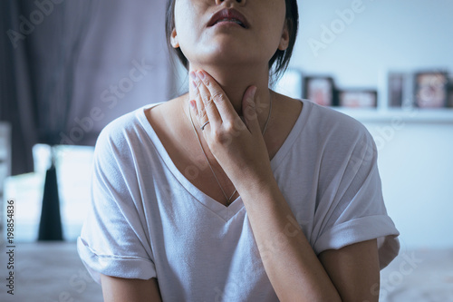 Woman have a sore throat,Female touching neck with hand,Healthcare Concepts