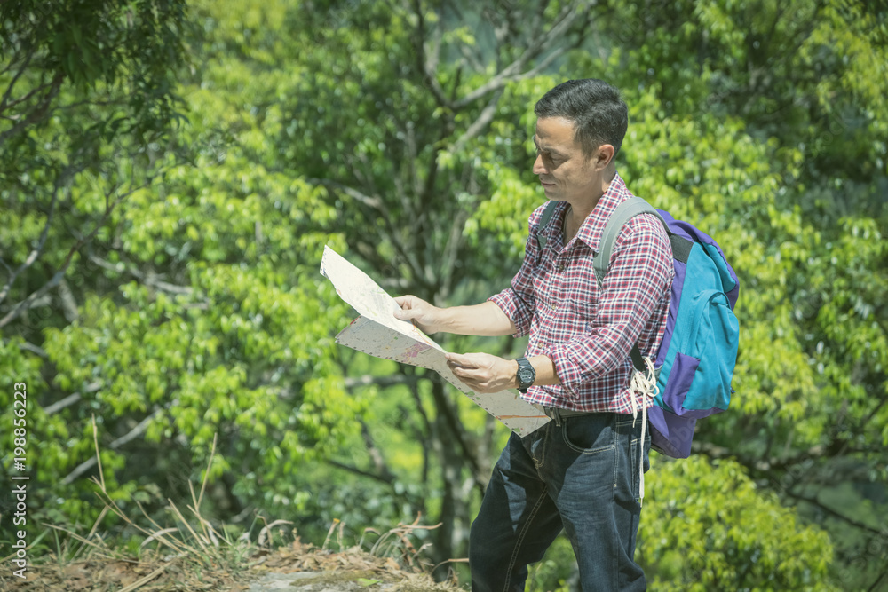Backpacker looking at map in forest. Backpacker looking at map in forest.