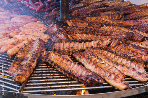 Gran Parrillada De Carne Asada Encendida Y Con Humo En Feria Al Aire Libre Costillas Y Carne De Cerdo Ternera Cordero Chorizos Y Salchichas Stock Foto Adobe Stock