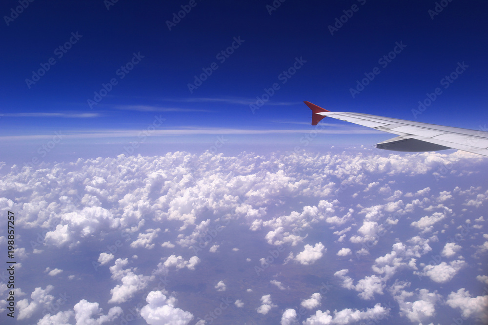 Fototapeta premium Airplane wing with beautiful cloud and blue sky on background, Amazing view from airplane window