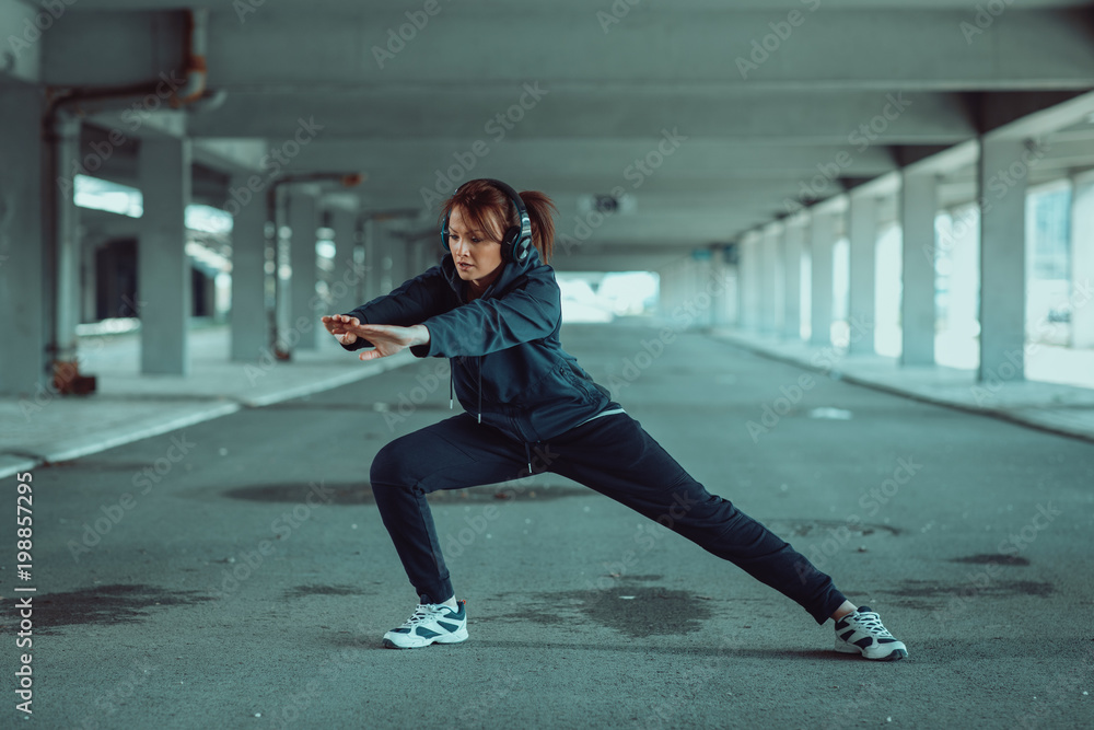 Young woman stretching legs before jogging