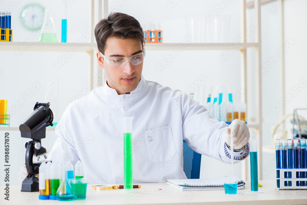 Young chemist student working in lab on chemicals Young chemist student working in lab on chemicals