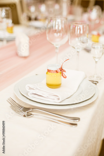 Details of decoration of Groom s and Bride s wedding table on wedding party. Decoration by pink fabric and flowers. Bonbonnieres with honey for guests