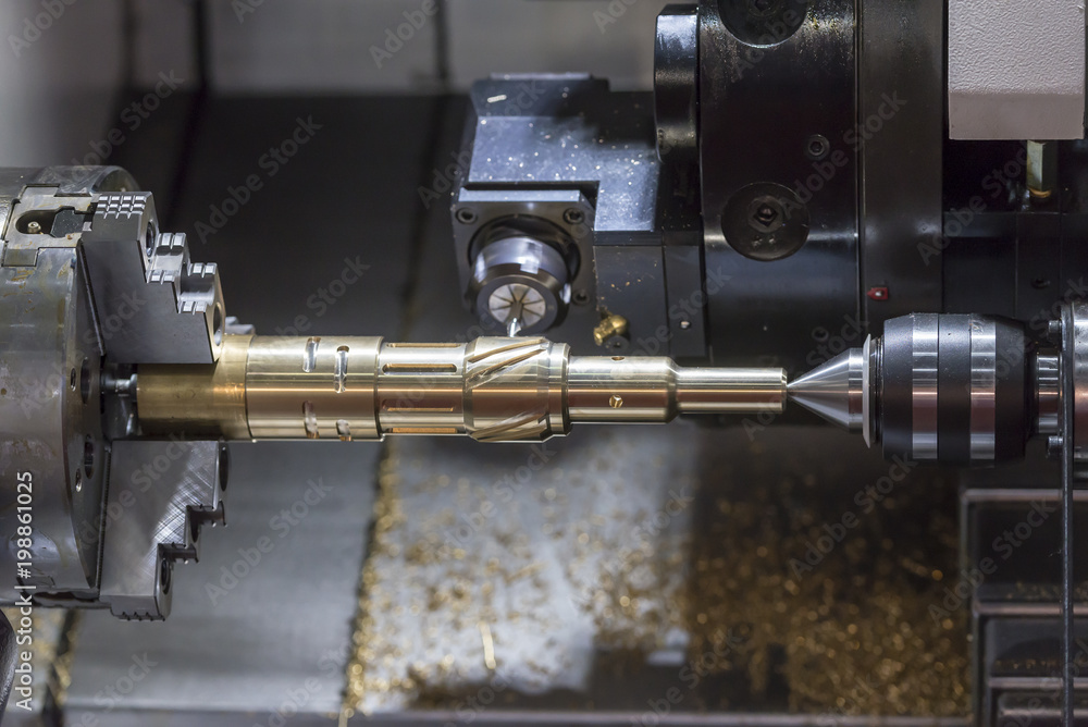 Fototapeta premium The CNC lathe machine cutting the brass shaft part by milling spindle.