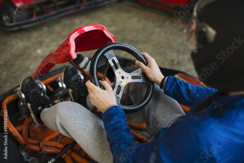 man holding the steering wheel of a sports car