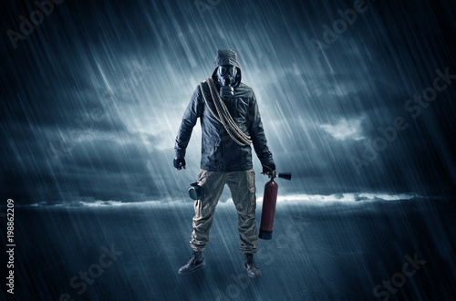 Terrorist in a stormy space with gas mask on his hand and weapons on his arm 