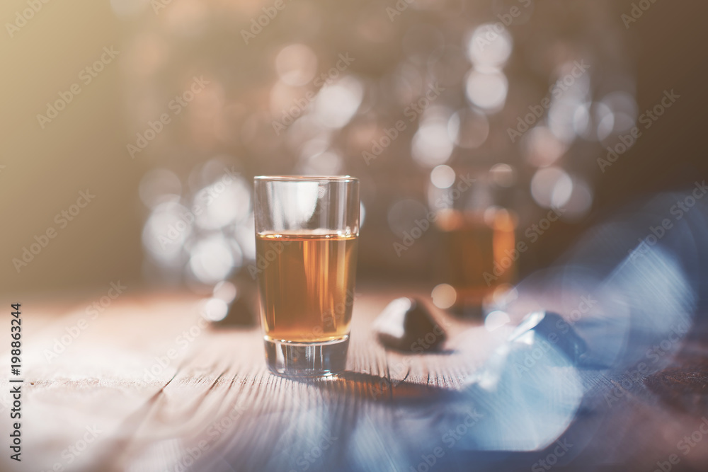 Italian amaretto liqueur on a wooden background with blurred background,