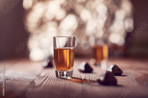 Glass of whiskey on wooden background blurred background, photo