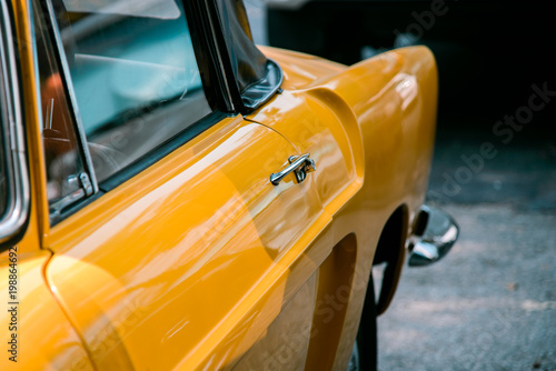 Close up handle door of yellow retro classic car 