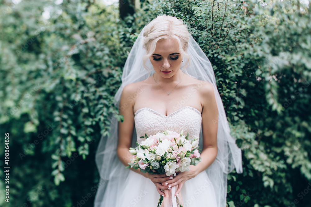 A bride in a white dress is holding a beautiful wedding bouquet. A bride in a white dress is holding a beautiful wedding bouquet.