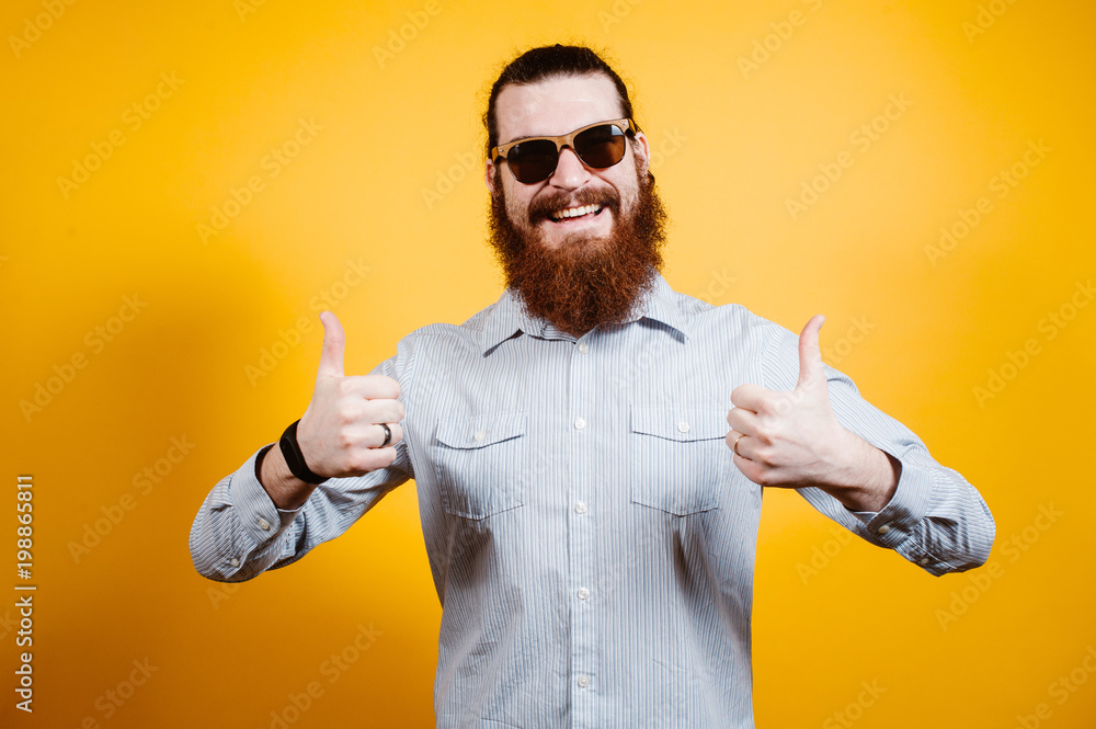 Happy bearded hipster man in casual showing thumbs up Happy bearded hipster man in casual showing thumbs up